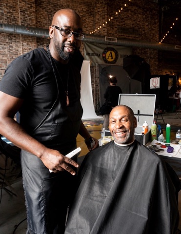 Smiling client seated beside his barber after a haircut